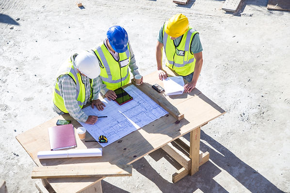 Three men looking at building plans.